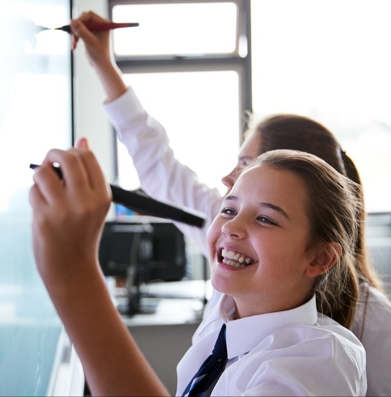 2 Female High School Students at interactive screen